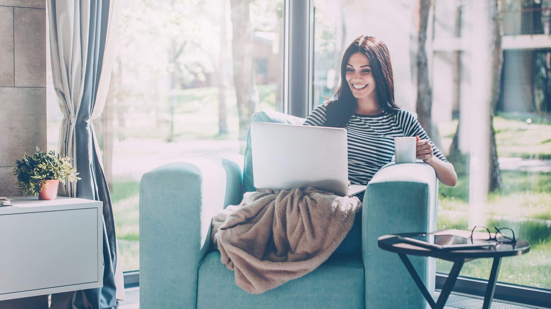 woman staying at home on laptop smiling