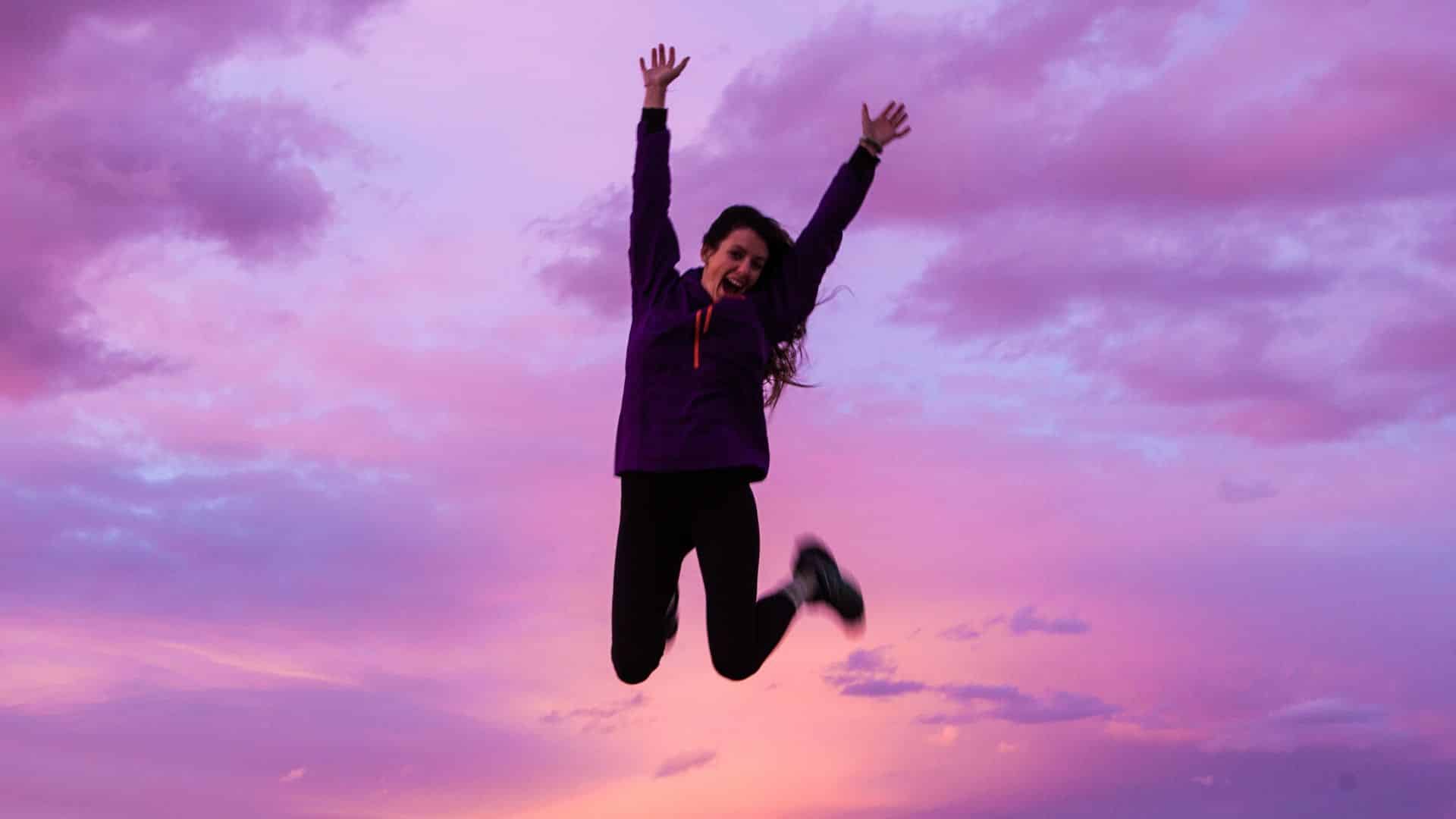 woman jumping in pink clouds