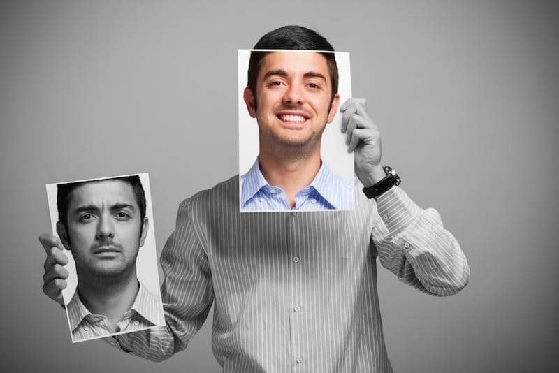 man holding up faces with different moods
