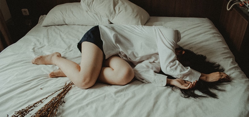 depressed woman lying on bed
